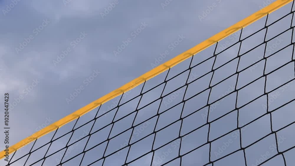 Beach volleyball net close-up. Fragment of a volleyball net on the beach against the blue sky. Sport, beach volleyball. Active recreation concept. Background. Detail of the yellow net. Sports ground Beach volleyball net close-up. Fragment of a volleyball net on the beach against the blue sky. Sport, beach volleyball. Active recreation concept. Background. Detail of the yellow net. Sports ground