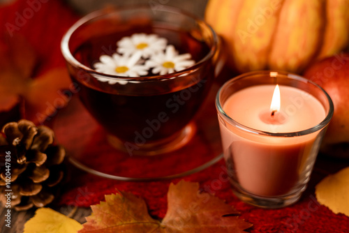 Autumn composition, tea, pumpkins, candle on the table. Autumn comfort at home