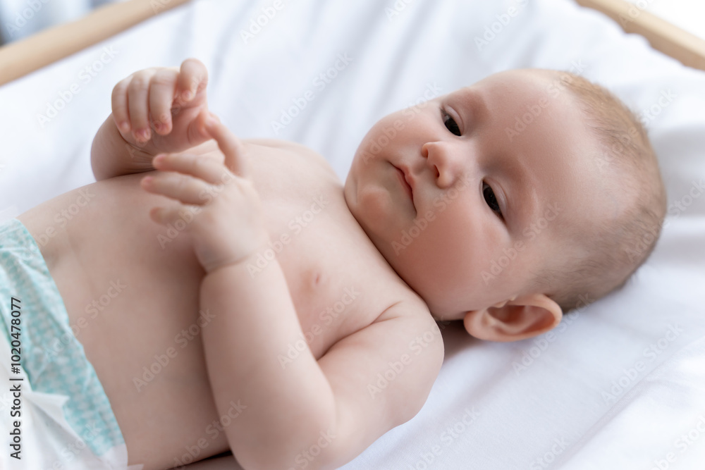 Cute infant baby girl or boy looking at camera with curious eyes Cute infant baby girl or boy looking at camera with curious eyes