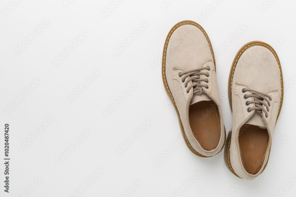 Beige suede shoes on color background, top view Beige suede shoes on color background, top view