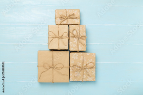 Gift boxes in Christmas tree shape on wooden background, top view