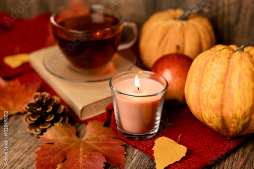 Autumn composition, tea, pumpkins, candle on the table. Autumn comfort at home