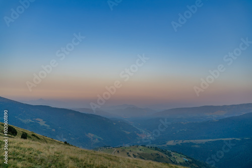 nuve aislada con luz de puesta de sol y paisaje de montaña photo