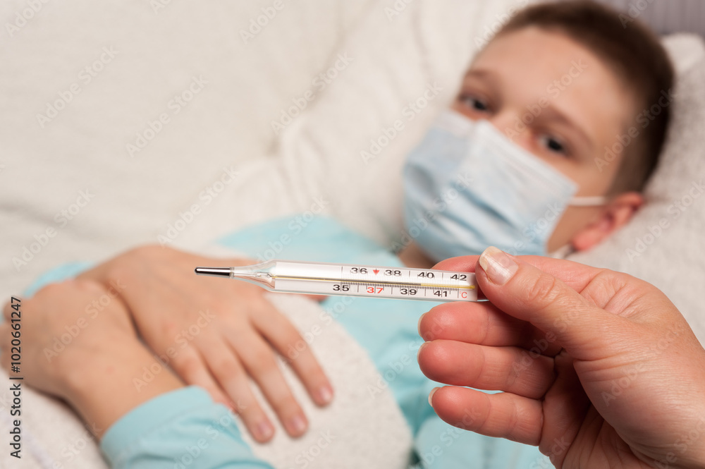 thermometer in the hand of a nurse on the background of a sick boy thermometer in the hand of a nurse on the background of a sick boy