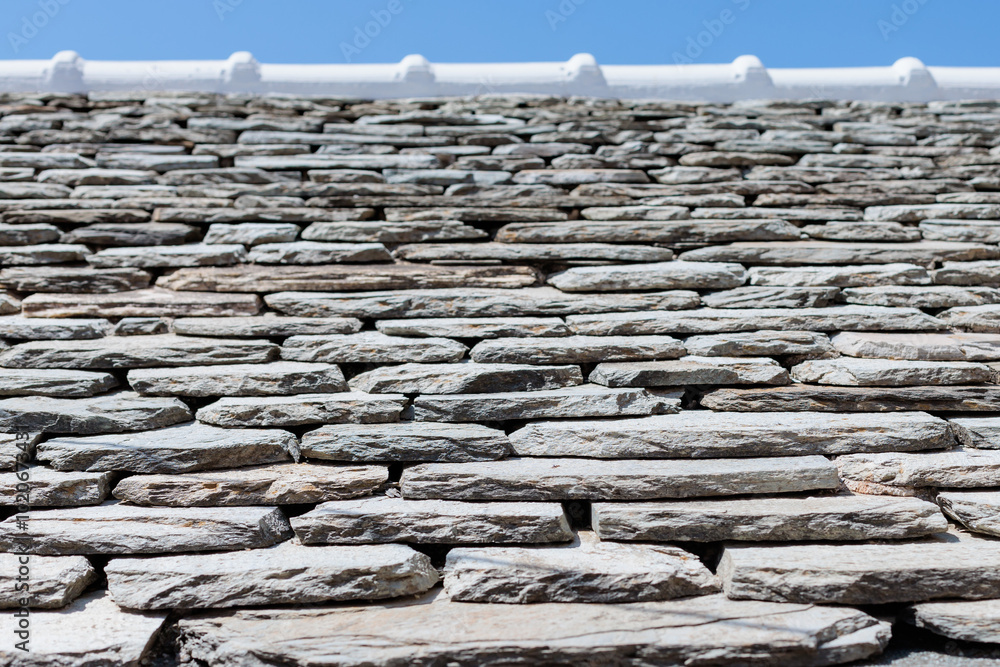 Close-up of a textured stone wall under a clear blue sky in a sunny setting Close-up of a textured stone wall under a clear blue sky in a sunny setting