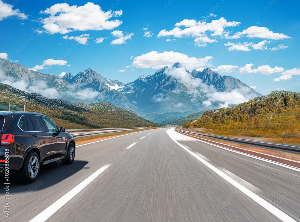 The car is driving along the highway surrounded by picturesque nature.