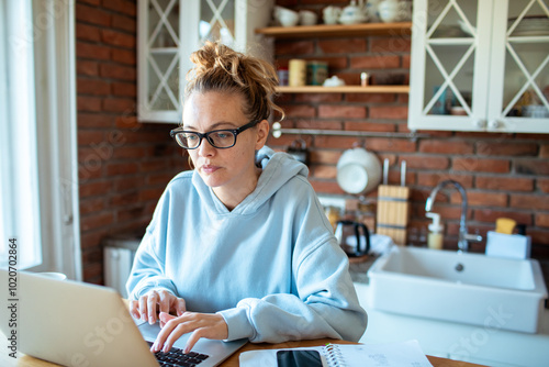 Young woman working from home on laptop photo