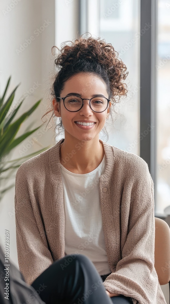 A young woman with curly hair smiles warmly, showcasing her confidence and style in a modern indoor setting. A young woman with curly hair smiles warmly, showcasing her confidence and style in a modern indoor setting.