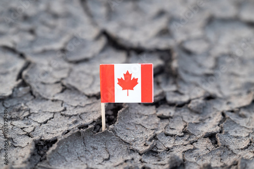 Flag of Canada in cracked dirt. Water problems, hot rainless weather in Canada