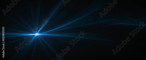 A blue light is shining on a black background. The light is bright and has a star shape