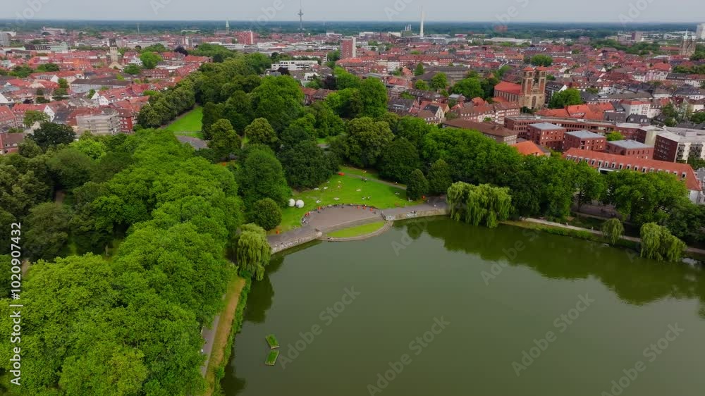 Aerial view of the promenade and Aasee Lake in Munster, germany. Lush green trees line the waterfront with the cityscape in the background Aerial view of the promenade and Aasee Lake in Munster, germany. Lush green trees line the waterfront with the cityscape in the background