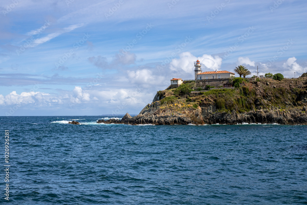 A picturesque lighthouse perched on a rocky cliff overlooking the vast ocean. The clear blue sky and calm waves create a serene atmosphere. A picturesque lighthouse perched on a rocky cliff overlooking the vast ocean. The clear blue sky and calm waves create a serene atmosphere.