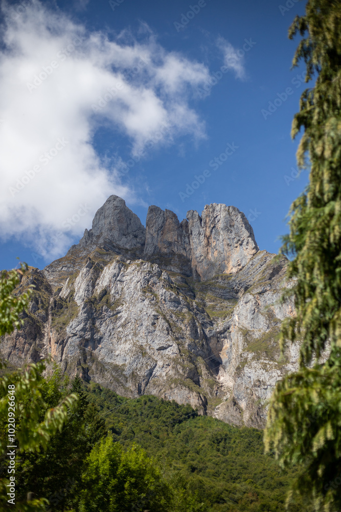 A breathtaking panorama of a majestic mountain range, with a dramatic cloud formation casting a shadow over the rugged peaks. Lush greenery covers the lower slopes, contrasting with the stark, rocky c A breathtaking panorama of a majestic mountain range, with a dramatic cloud formation casting a shadow over the rugged peaks. Lush greenery covers the lower slopes, contrasting with the stark, rocky c
