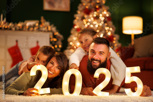 Canvas Print Parents and children celebrating New Year at home holding numbers 2025