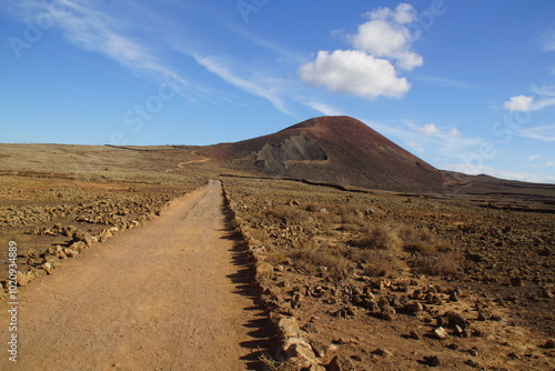 desertic and lonely road landscape with volcano, chemin solitaire dans un paysage désetique et empierré avec un volcan 