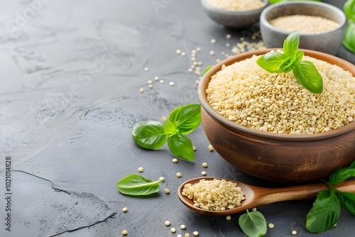 Bowl of quinoa with basil leaves on a dark grey background. photo