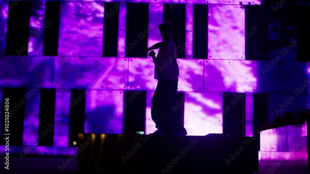 Young Male Dancer Doing Freestyle At Night Against A Vibrant Pink Facade Young Male Dancer Doing Freestyle At Night Against A Vibrant Pink Facade
