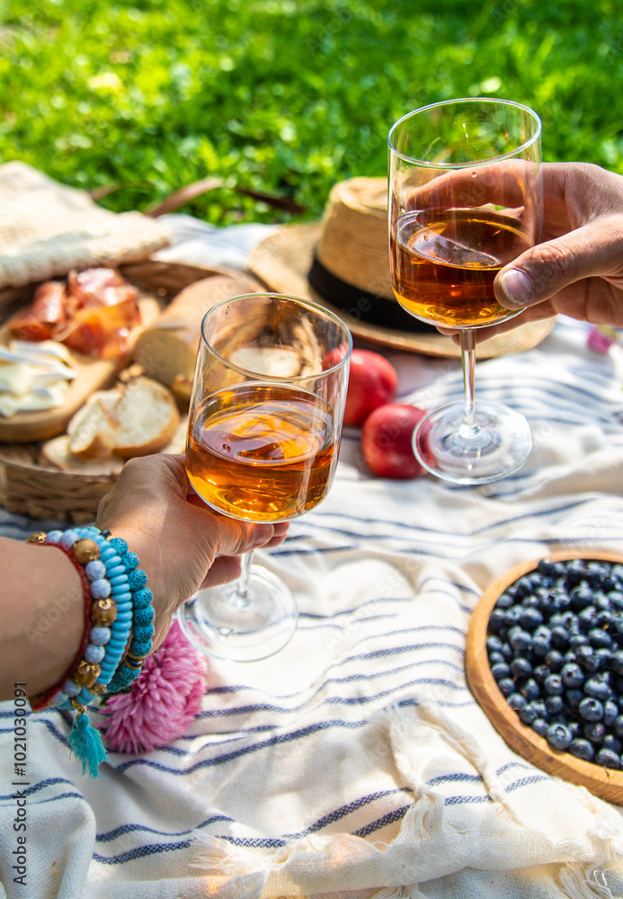 Wine in hands of woman at picnic. Selective focus. Wine in hands of woman at picnic. Selective focus.