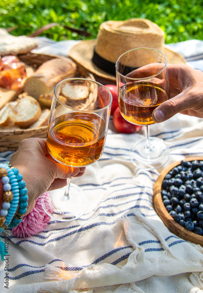 Wine in hands of woman at picnic. Selective focus. Wine in hands of woman at picnic. Selective focus.
