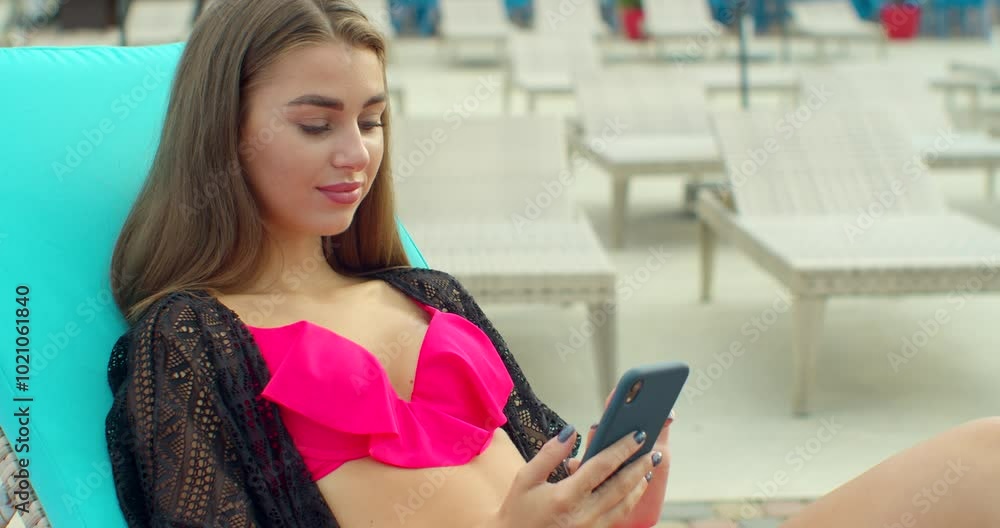 Summer girl using smartphone and sunbathing at swimming pool. Female model relaxing outdoors at sunny day. Summer girl using smartphone and sunbathing at swimming pool. Female model relaxing outdoors at sunny day.