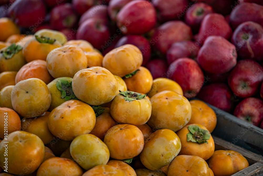 Fresh persimmons displayed on a farmer's market counter Fresh persimmons displayed on a farmer's market counter