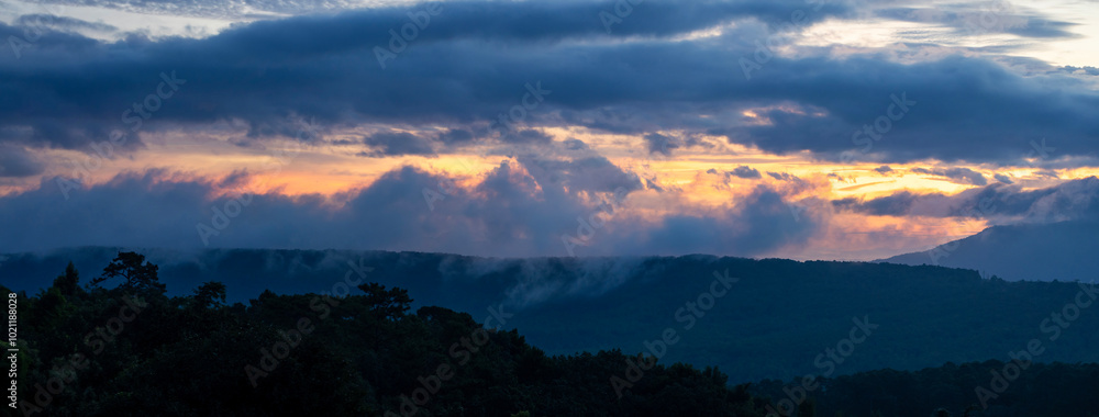 Naklejka premium Amazing colorful sunrise over the rainforest mountains with fog and mist at the Ob Luang natinoal park, Chiangmai, Thailand