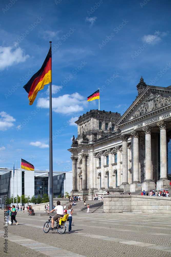 Obraz premium Berlin, Germany, July 29 2009, Visitors Explore the Reichstag Facade With German Flags in Berlin