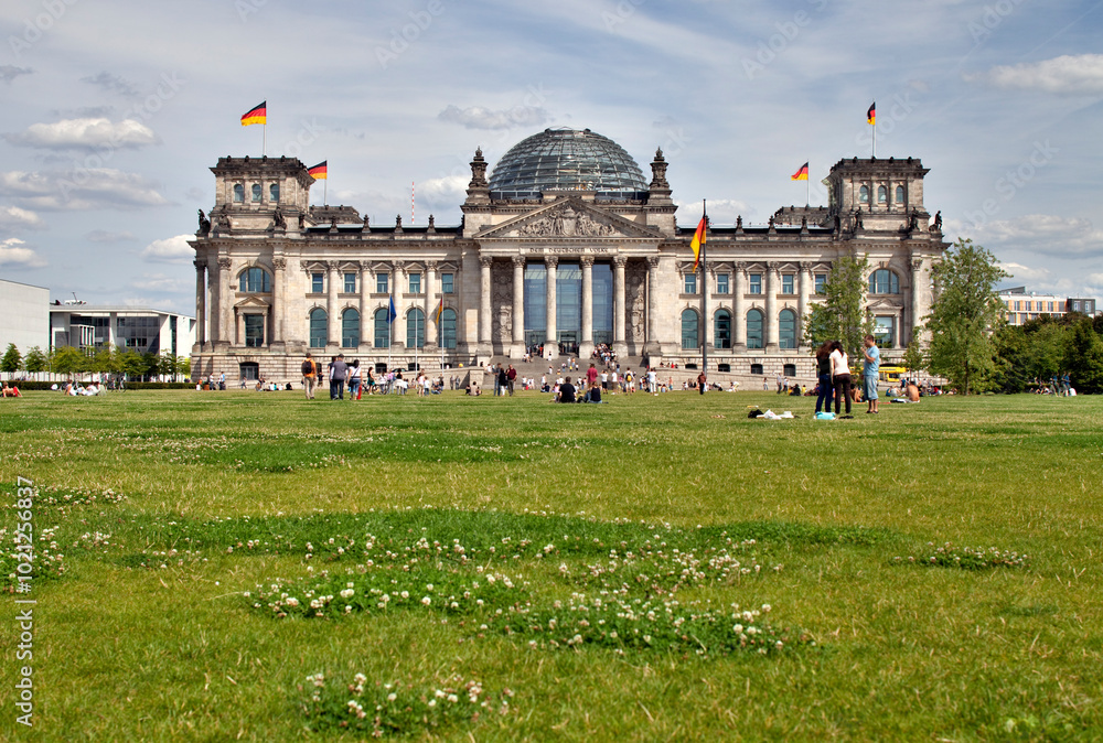 Naklejka premium Berlin, Germany, July 29 2009, Visitors Enjoy a Sunny Day Outside the Reichstag Building in Berlin