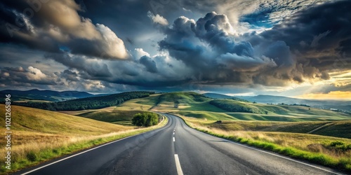 Asphalt road winding through rolling hills under a dramatic sky, offering a sense of freedom and adventure.