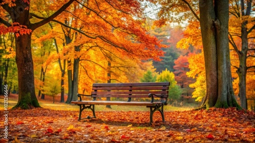 A solitary wooden bench sits nestled amidst a vibrant tapestry of golden and crimson leaves, offering a tranquil respite in the heart of autumn's embrace.