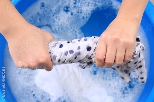 Tableau sur toile Woman wringing garment over basin, closeup. Hand washing laundry