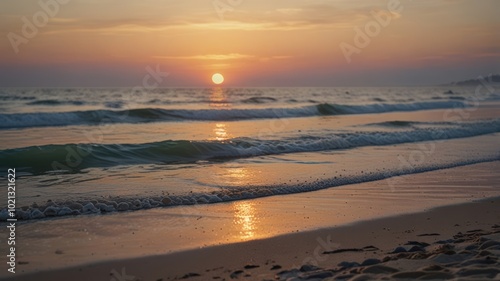 A beautiful sunset over the ocean with waves crashing on the sandy shore.