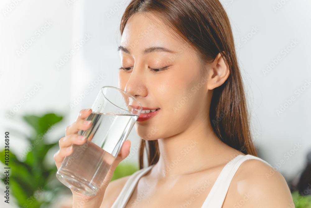 Woman smiling and holding a glass of mineral water Woman smiling and holding a glass of mineral water