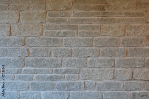 Close up of a rectangular gray stone wall fireplace inside a house.