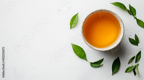 Wallpaper Mural A cup of tea on a white background, surrounded by scattered green leaves, creating a fresh and minimalist aesthetic. Torontodigital.ca