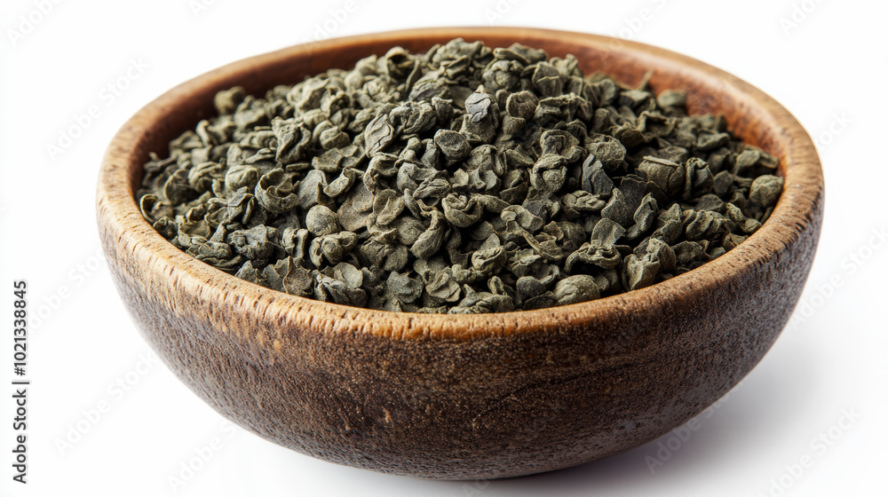A wooden bowl filled with dried green tea leaves, likely Gunpowder tea, neatly arranged and displayed against a white background. A wooden bowl filled with dried green tea leaves, likely Gunpowder tea, neatly arranged and displayed against a white background.