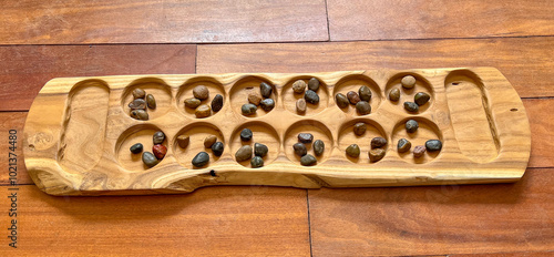 Handcrafted Wooden Mancala board with Colorful Stone Seeds - A boardgame of Arab, Muslim, African, and Asian Heritage Spread Through Migration