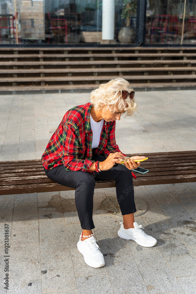 Female tourist over 60 looking at her phone. Senior lifestyle concept. Female tourist over 60 looking at her phone. Senior lifestyle concept.