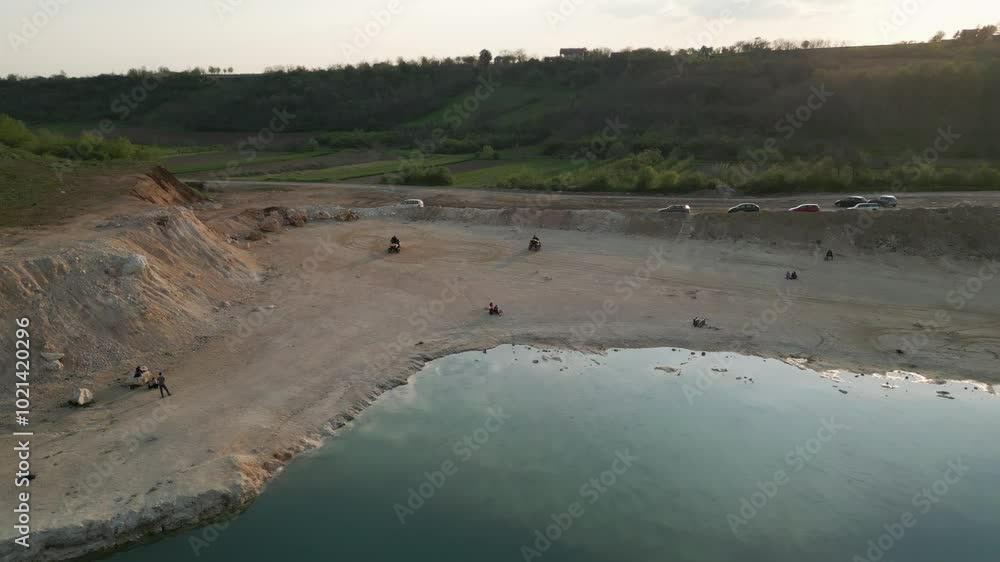 Drone aerial view of lake with quad bikers Drone aerial view of lake with quad bikers