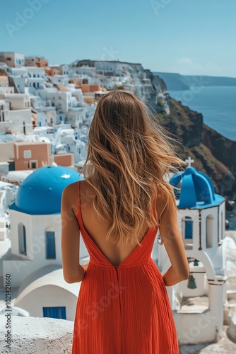 A woman in a red dress gazes at a beautiful coastal view, showcasing the stunning architecture of Santorini.