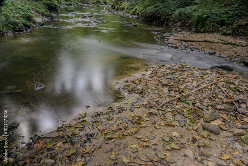 Langzeitbelichtung eines kleinen Wasserfalls im Wald photo