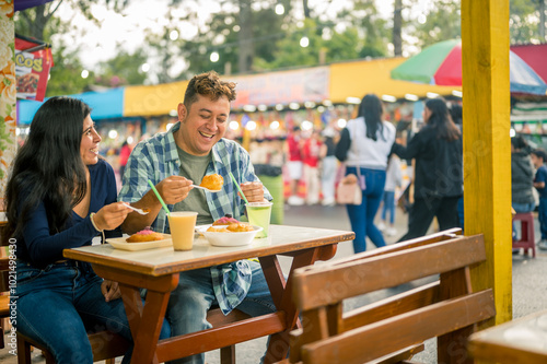 Foto Two young Latinos enjoy their food at a street food stand.