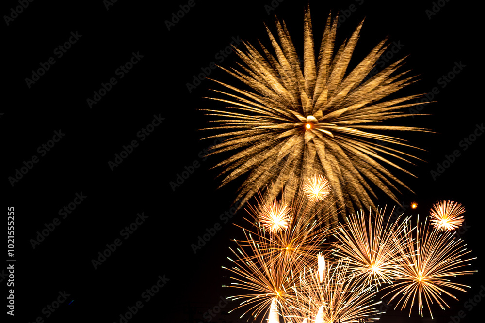 Naklejka premium Bright golden sparks of fireworks on the black sky