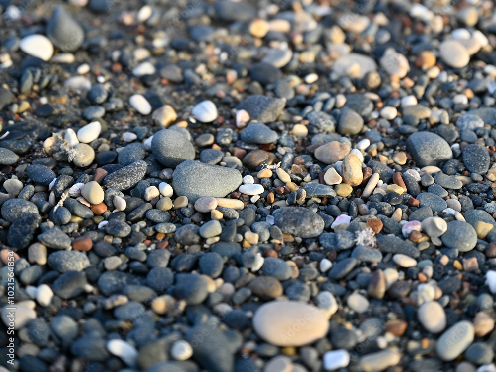 A beach with rocks and pebbles, and small stones up close. A beach with rocks and pebbles, and small stones up close.