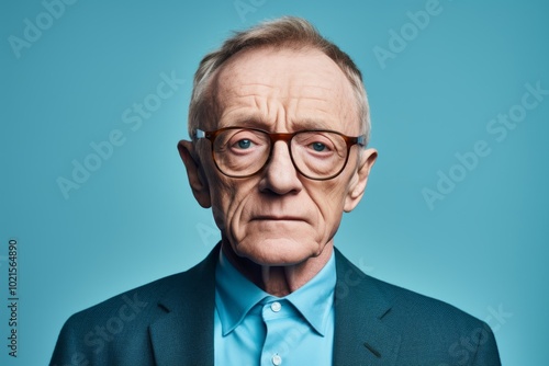 Portrait of an old man with glasses on a blue background.