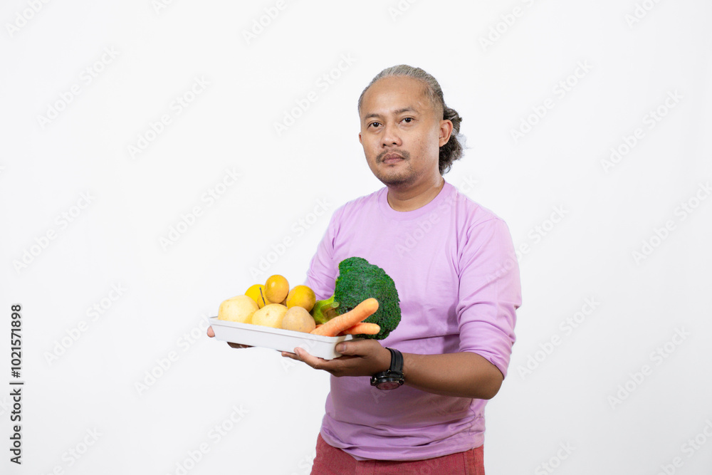 curly-haired Asian adult male carrying a tray of fresh vegetables while pointing at it, healthy and nutritious fresh vegetables eating campaign, healthy lifestyle curly-haired Asian adult male carrying a tray of fresh vegetables while pointing at it, healthy and nutritious fresh vegetables eating campaign, healthy lifestyle
