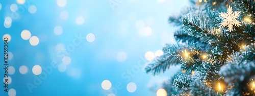 A Christmas tree adorned with garland and snowflakes against a blue background, with glowing lights and a bokeh effect