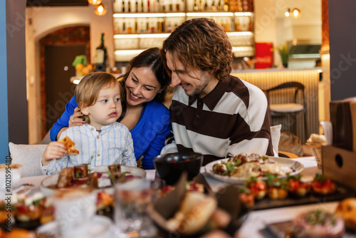 Family of three eating in a restaurant delicious food. Food and drink concept.