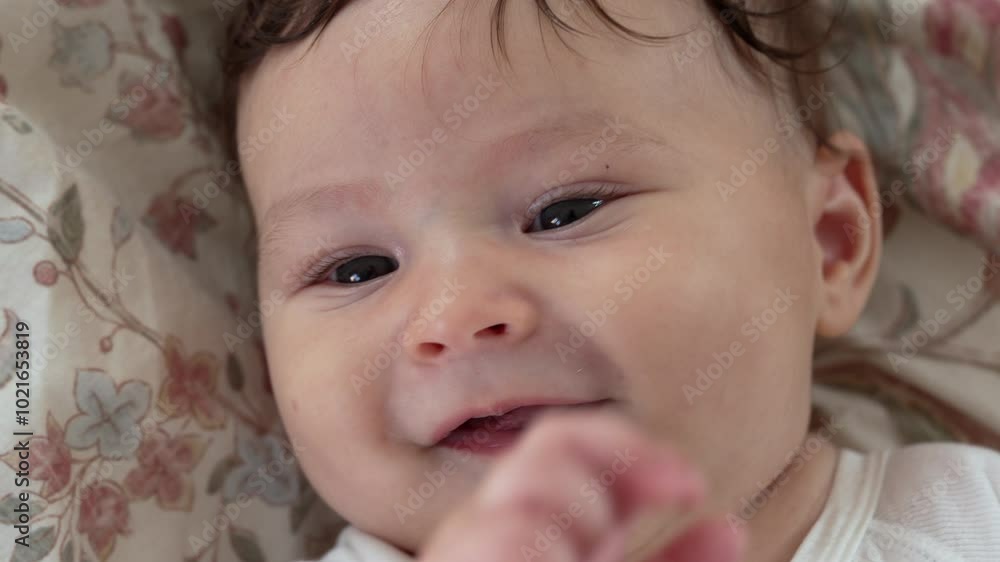 Baby with soft smile lying on floral blanket, baby looking relaxed and content, baby gazing softly with eyes full of curiosity, peaceful and joyful baby resting comfortably Baby with soft smile lying on floral blanket, baby looking relaxed and content, baby gazing softly with eyes full of curiosity, peaceful and joyful baby resting comfortably