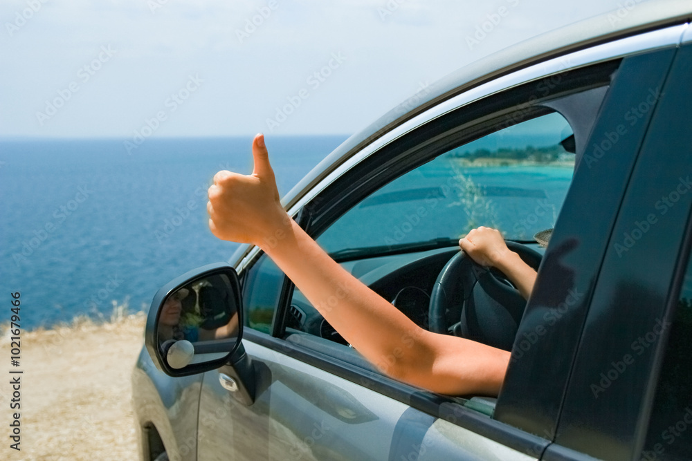 Naklejka premium A happy girl from car at sea greece background